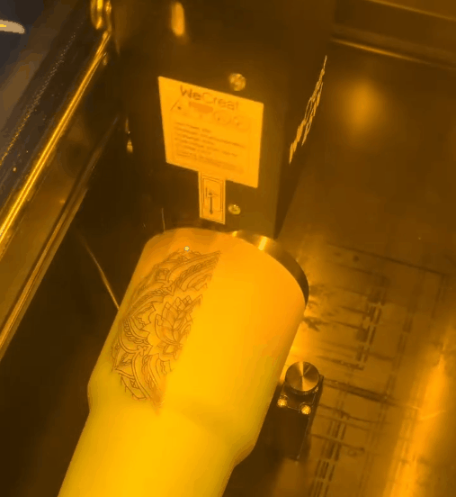Laser engraver creating a custom design on a cup